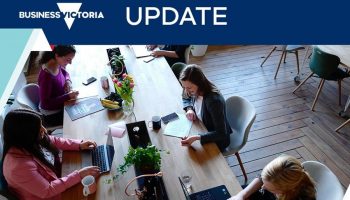 People sitting around a table with laptops working
